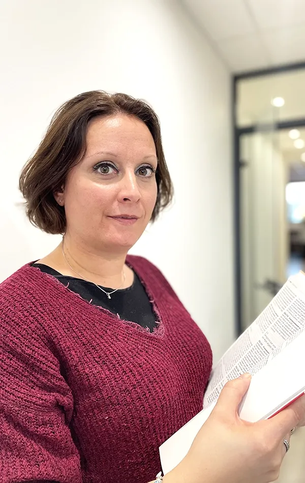 Maître Virginie Sevin avec un livre dans les mains